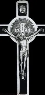 Silver crucifix with intricate design on a black background.