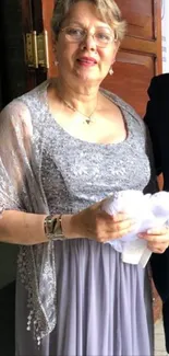 Elegant silver-clad woman at event doorway.