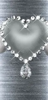 Silver heart with wings and crystal drop on metallic background.