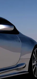 Elegant silver sports car against a blue sky.