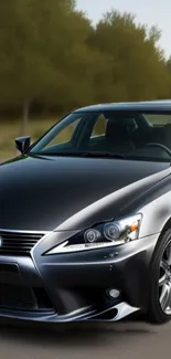 Luxury dark gray car driving through a serene forest road.