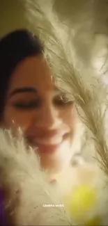 Smiling woman partially hidden by pampas grass, with a gentle yellow glow.