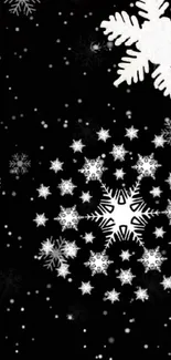 Black wallpaper with elegant white snowflakes creating a winter charm.