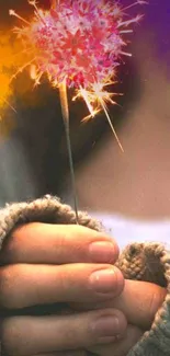 A cozy hand holding a glowing sparkler with warm, festive colors.