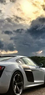 Sleek sports car beneath a cloudy sky, perfect for a stylish wallpaper.