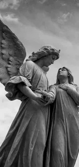 Black and white image of a stone angel statue against a cloudy sky.