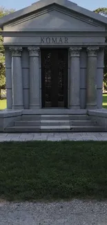 Stone mausoleum amidst lush green landscape, capturing historic charm.