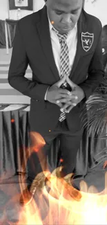 Person in a suit with flames around them in grayscale setting.