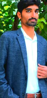 Stylish man in a suit with green leafy background.