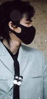 Person in a stylish suit with a black mask, looking to the side.