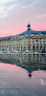 Elegant historic building reflecting on water at sunset with serene sky.