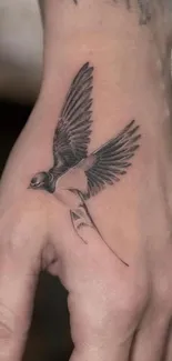 Hand tattoo with swallow design on beige background.