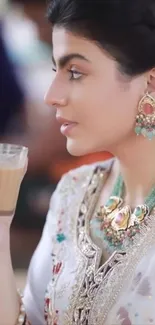 Elegant woman with jewelry enjoying tea.