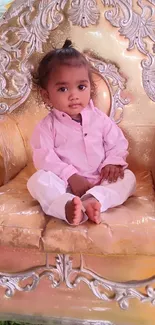 Child seated on an ornate golden throne.