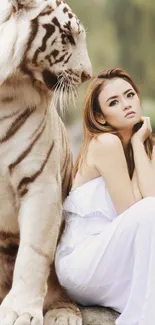 Woman sitting with a white tiger in serene nature scene.