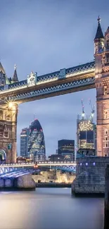 Tower Bridge illuminated at dusk with city skyline in the background.