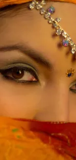 Close-up of eyes with orange and jeweled adornments.