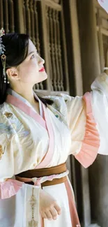 Beautiful woman in hanfu holding fan elegantly.