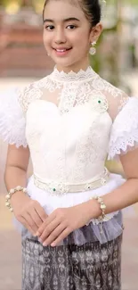 Elegantly dressed person in traditional attire with lace and bead details.