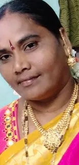 Woman in vibrant saree and gold jewelry.