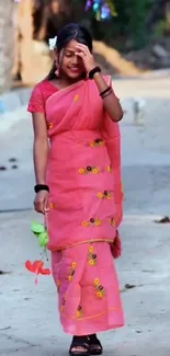 Young girl in pink traditional sari on street.