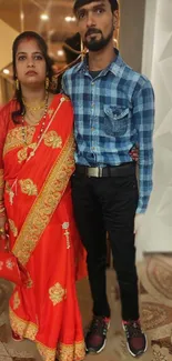 Couple in traditional red and blue attire with a cultural flair.