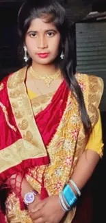 Portrait of a woman in vibrant red and gold traditional attire.