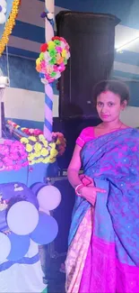 Woman in colorful traditional sari with decorative background.