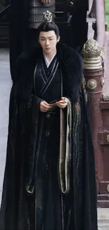 Man in traditional black robe standing elegantly outdoors.