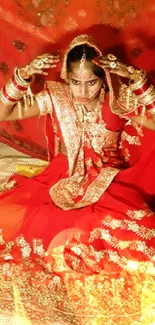 Traditional bride in red attire seated elegantly, showcasing cultural beauty.