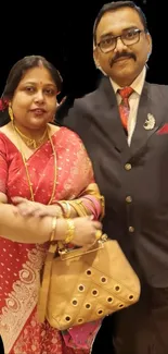 Traditional couple in vibrant attire on a stylish mobile wallpaper.