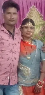 Couple in colorful traditional attire posing elegantly.