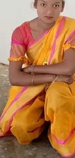 Person in vibrant, traditional attire sitting.