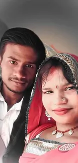 A couple in traditional attire posing happily for a portrait.