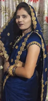 Woman in a beautiful blue saree posing elegantly.