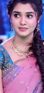 Woman in a pink saree with intricate jewelry and braided hairstyle.