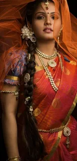 Portrait of woman in traditional orange attire, adorned with jewelry.