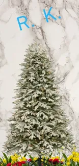 Snow-covered Christmas tree on marble with flowers.