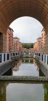 Serene urban reflection under an elegant archway with classic buildings.