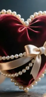 Red velvet heart adorned with pearls and a bow.