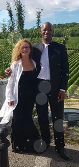 Elegant couple posing in a vineyard landscape.