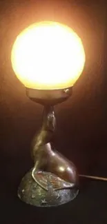 Vintage lamp with glowing orb and sculpted base in dark setting.