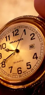 Close-up of a vintage gold watch face showing time details.