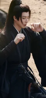 Warrior in black attire on a sandy background, exuding elegance.