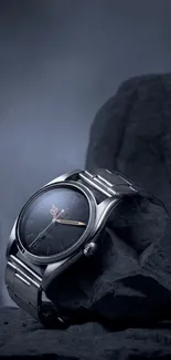 Sleek watch resting on rugged rocks in a dark, sophisticated setting.