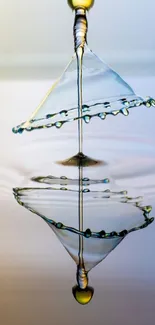 Artistic water droplet splash with reflection on light blue background.