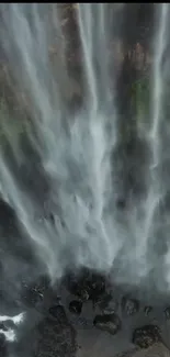 Majestic waterfall with cascading streams of water over rocks and surrounded by greenery.