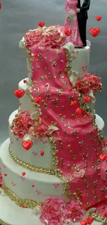 Elegant wedding cake with pink floral decorations and topper.