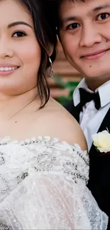 Elegant wedding couple with white attire smiling together.