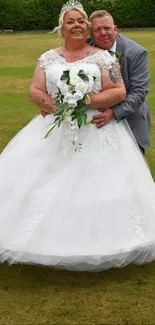 Bride and groom embracing in a green outdoor setting.